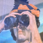 From the movie Boy in the Plastic Bubble, picture shows Todd looking through binoculars at kids next door.