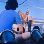 A picture from the movie "The Boy in the Plastic Bubble" of Todd and Gina on the beach.