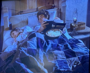 In the Little House on the Prairie episode called School Mom, Pa is reading and eating popcorn in bed.